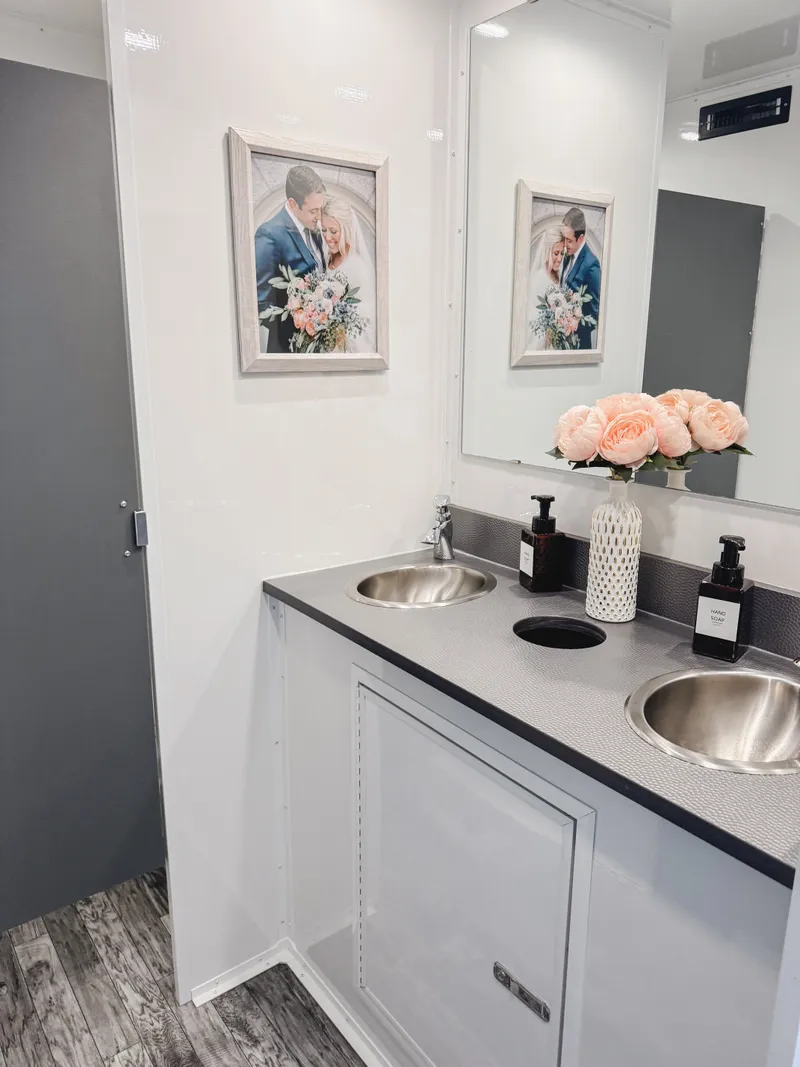 view of sinks, with wedding artwork and flowers